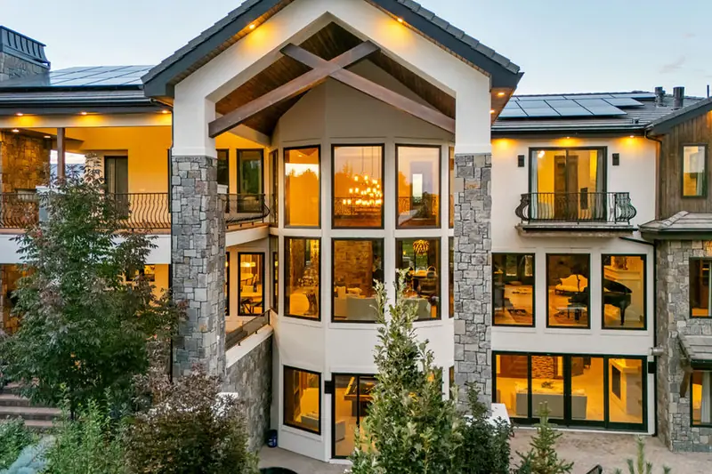 Stone and timber home glowing at dusk